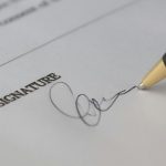 Businessman signing a commercial lease contract with the help of a real estate solicitor vancouver to protect his business interests.